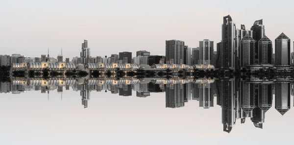 Reflection of buildings in lake against sky