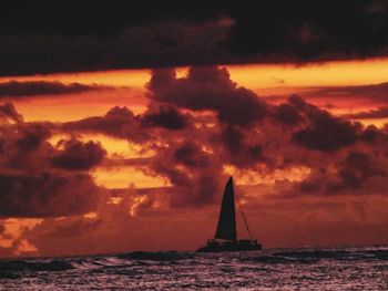 Silhouette sailboat sailing on sea against sky during sunset
