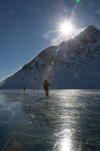 Man standing on snow covered mountain against sky