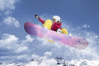 Low angle view of person paragliding on snow covered mountain