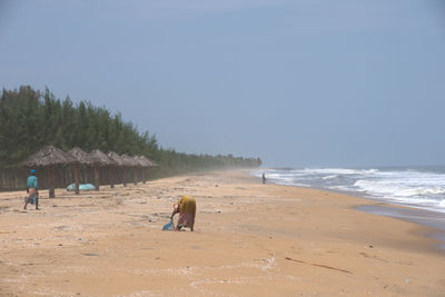 People on beach against clear sky