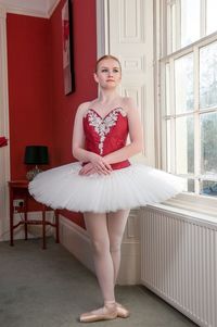 Woman in tutu dancing at home