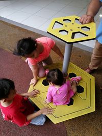 High angle view of siblings on playing equipment