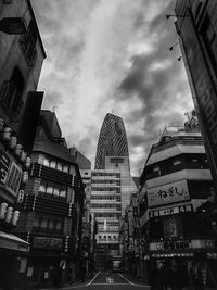 Buildings in city against cloudy sky