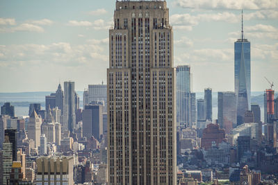 Skyscrapers in city against cloudy sky