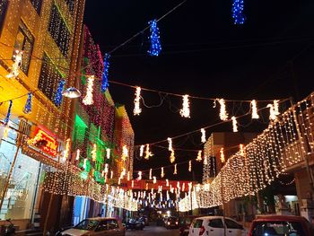 Low angle view of illuminated christmas lights against sky at night