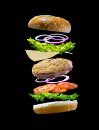 Close-up of burger against black background