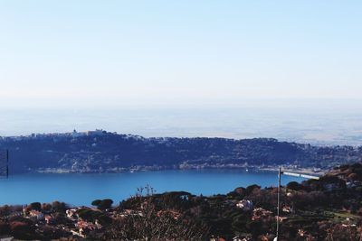 Cityscape by sea against clear sky