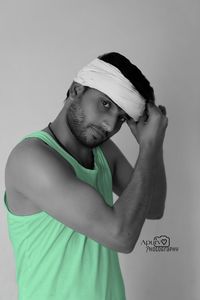 Portrait of young man standing against white background