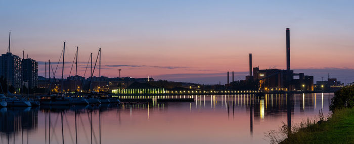 Beautiful night city skyline against a colorful sky.an old power plant casting reflections on water.