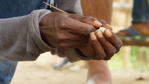 Midsection of man holding wood 