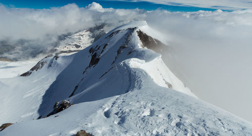 Scenic view of snow covered mountains against sky