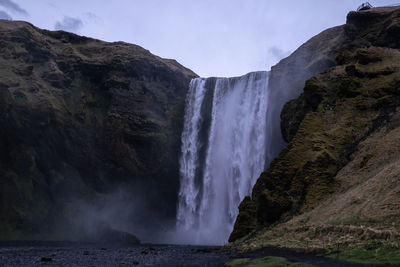 Scenic view of waterfall against sky