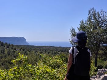 Woman standing by plants against sky