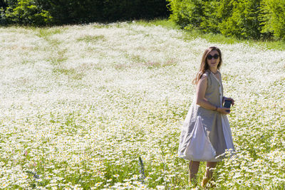 Women with dress in field of daisy flowers during sunlight