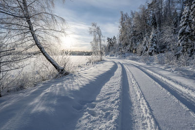 Snow covered road against sky during winter