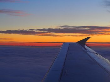 Close-up of airplane wing over sea against sky