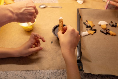 High angle view of hands holding food on table