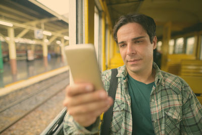 Portrait of man holding mobile phone