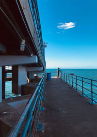 Pier over sea against blue sky