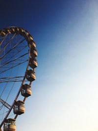 Low angle view of ferris wheel against clear blue sky