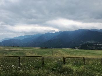 Scenic view of field and mountains against sky