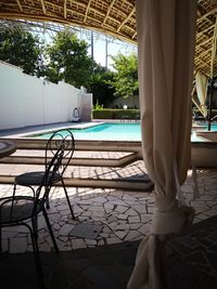 Low section of man standing by swimming pool