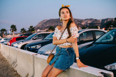 Portrait of woman standing by car