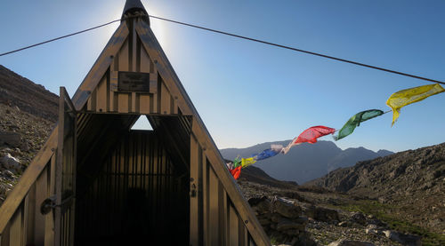 Low angle view of flags hanging on mountain against sky