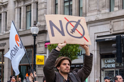 People on road against buildings in city