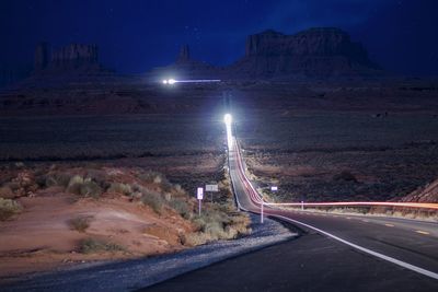 Light trails on road against sky at night