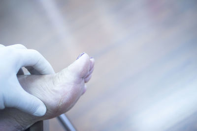 Cropped hand of doctor examining woman leg at hospital