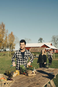 Mid adult man selling organic vegetables on table at farmer's market