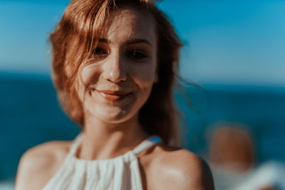 Close-up portrait of young woman against sky