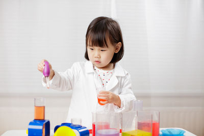 Cute girl doing scientific experiment in school