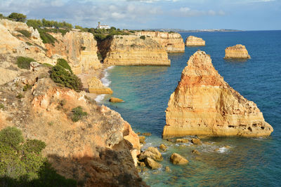 Rock formations by sea against sky