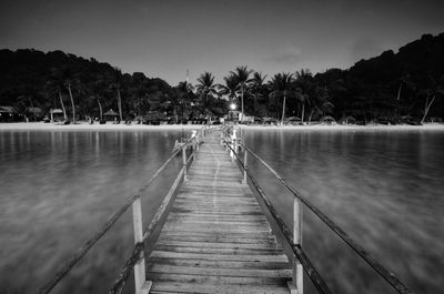 Wooden pier on lake against sky