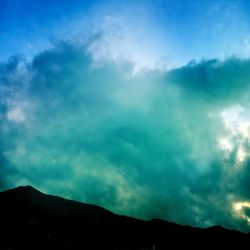 Scenic view of mountains against cloudy sky