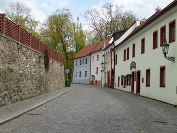 Footpath amidst houses and buildings against sky