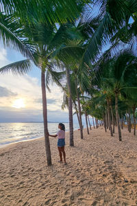 Rear view of woman walking at beach