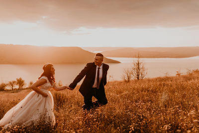 Rear view of couple standing on field