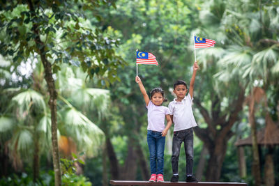 People with flag against trees