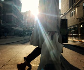 Man on footpath in city on sunny day