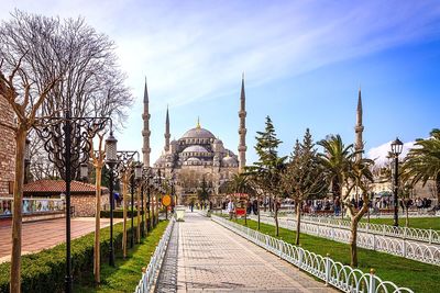 Walkway leading towards blue mosque against sky