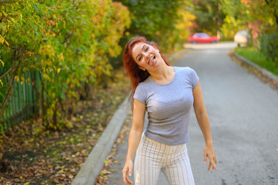 Portrait of smiling young woman standing on road