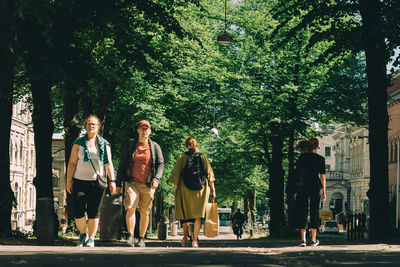 People walking by trees in city