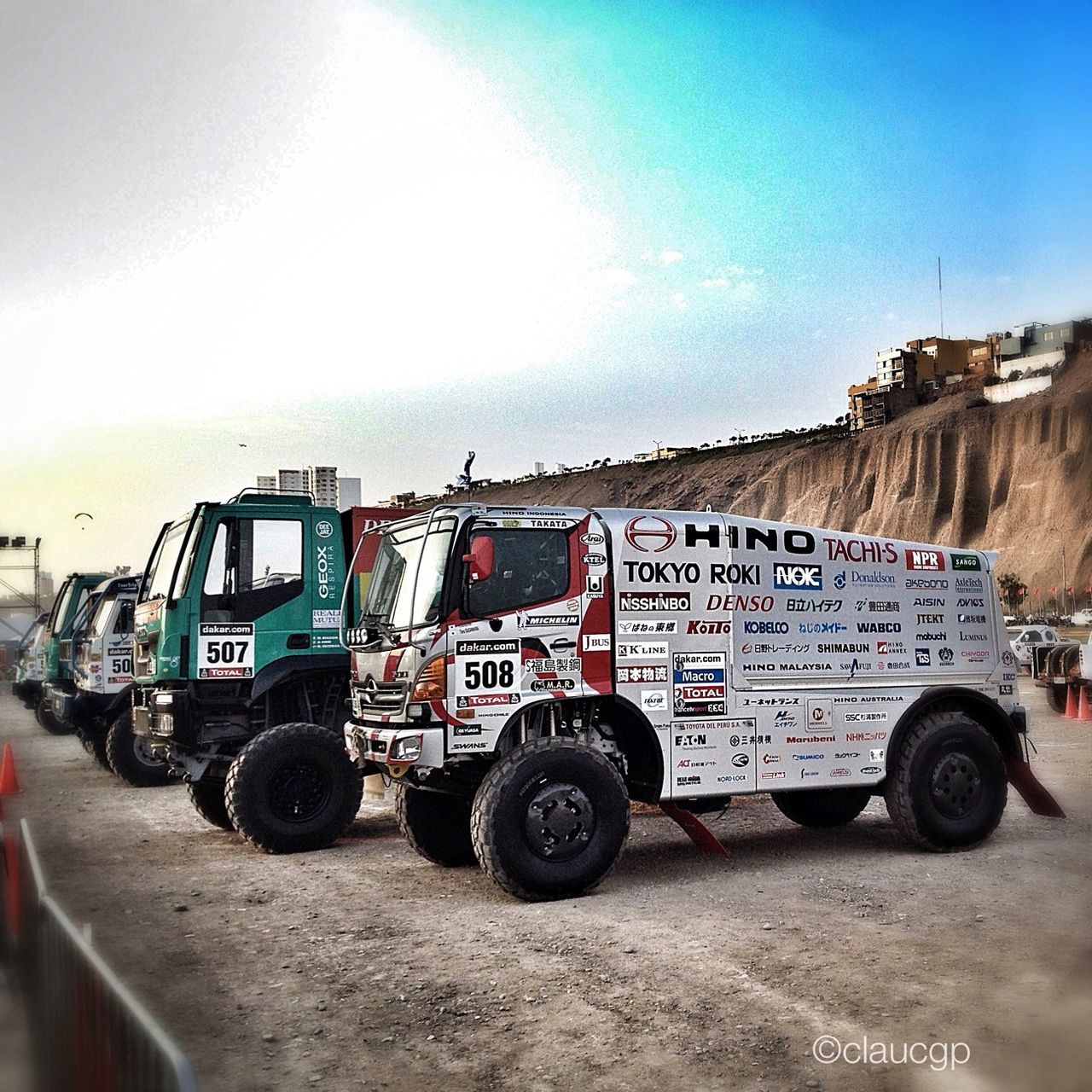 land vehicle, transportation, sky, mode of transport, car, text, western script, built structure, day, architecture, building exterior, outdoors, communication, travel, no people, sand, clear sky, sunlight, abandoned, road