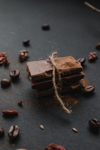 Close-up of tied up sweet food with roasted coffee beans on table