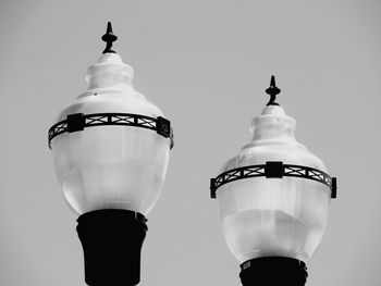 Low angle view of street lamps against clear sky in black and white 