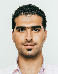 Portrait of confident young man against white background